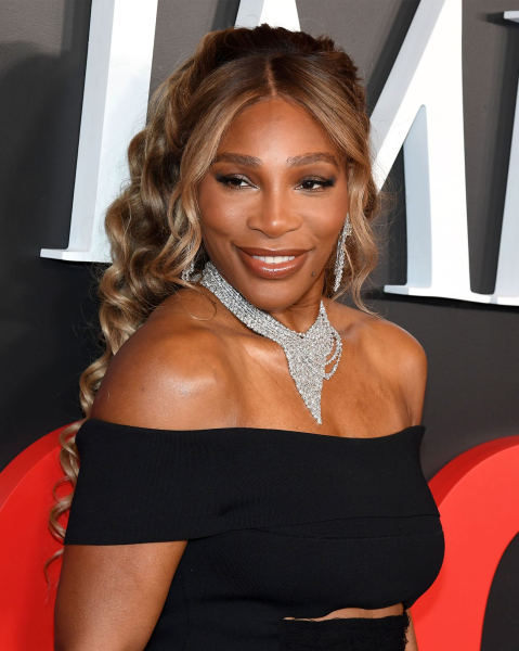 Serena Williams poses in a black off the shoulder dress and diamond necklace